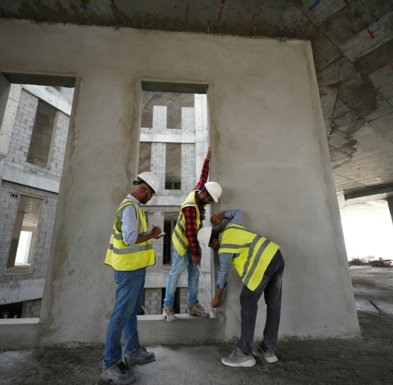 a-group-of-men-standing-next-to-each-other-in-front-of-a-building.jpg a group of men standing next to each other in front of a building